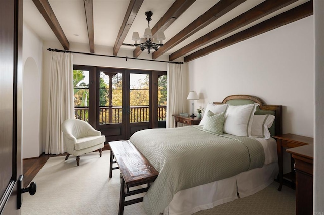 bedroom with an inviting chandelier, beamed ceiling, carpet flooring, and access to exterior