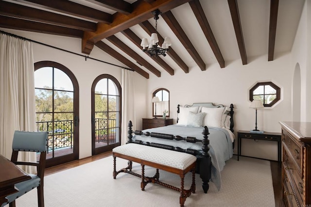 bedroom featuring access to exterior, a notable chandelier, light wood-style floors, and vaulted ceiling with beams