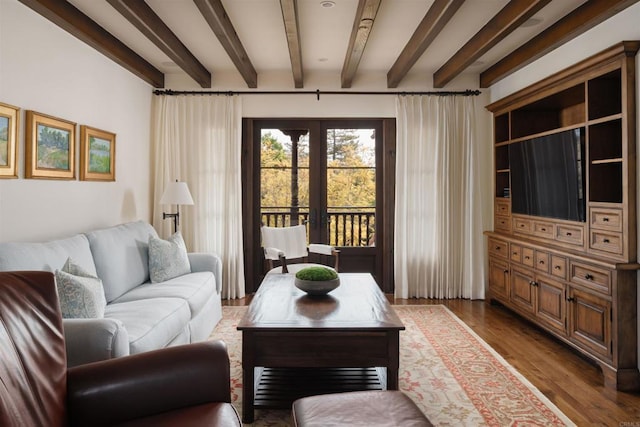 living area with beamed ceiling, french doors, and wood finished floors