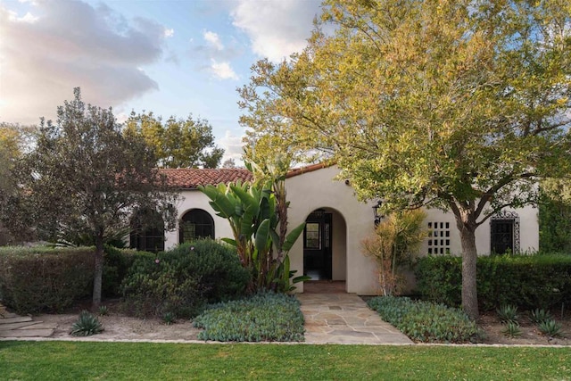 mediterranean / spanish-style home with stucco siding and a tile roof