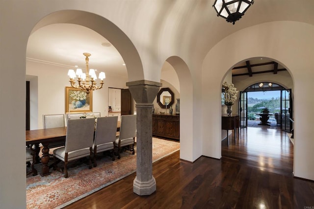 dining room with wood finished floors, arched walkways, baseboards, a chandelier, and vaulted ceiling with beams