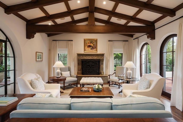 interior space with a premium fireplace, wood finished floors, and vaulted ceiling with beams