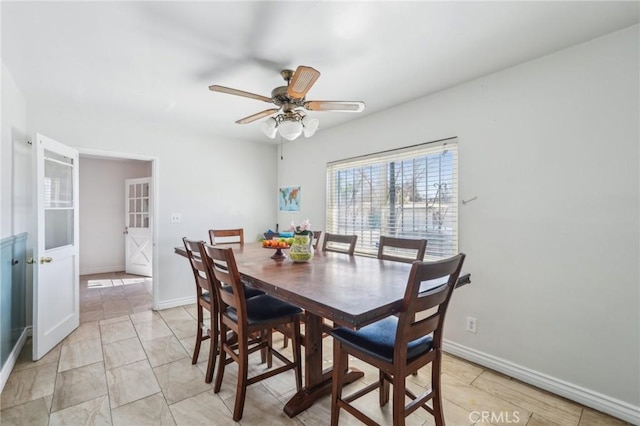 dining space featuring ceiling fan and baseboards