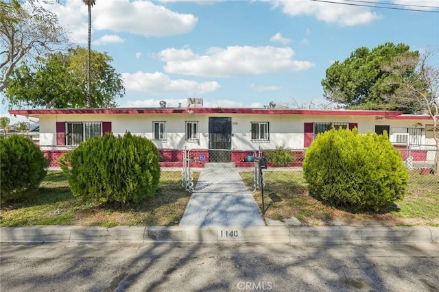 single story home featuring a fenced front yard and a gate