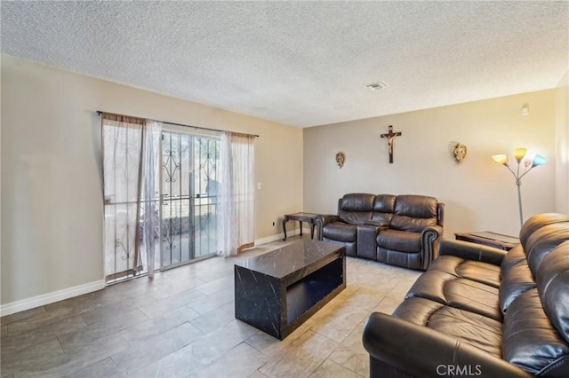 living area featuring visible vents, a textured ceiling, and baseboards