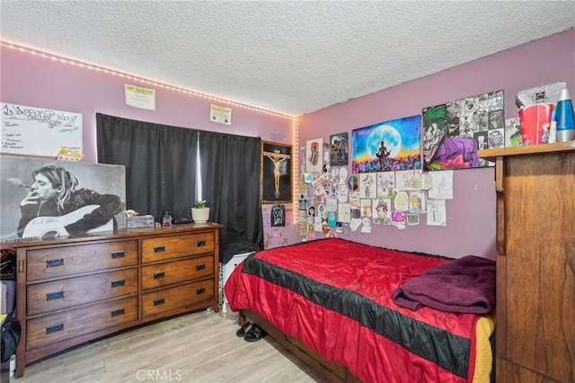 bedroom featuring a textured ceiling and wood finished floors