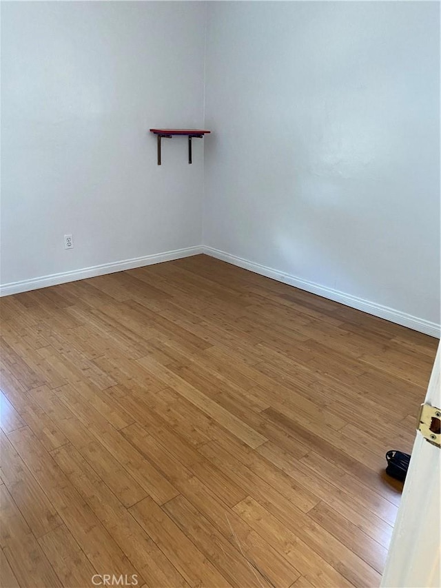 unfurnished room with light wood-type flooring and baseboards