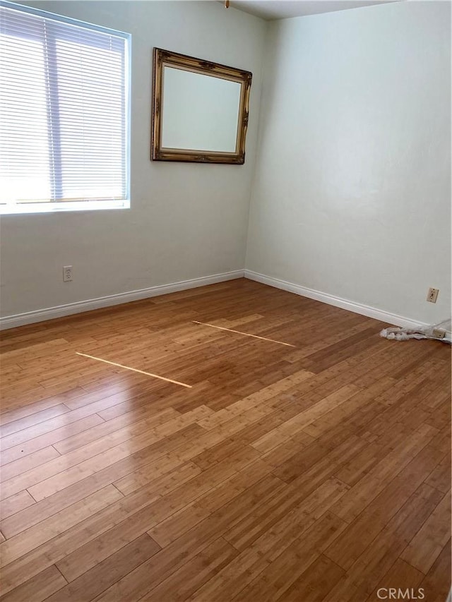 empty room featuring baseboards and wood finished floors