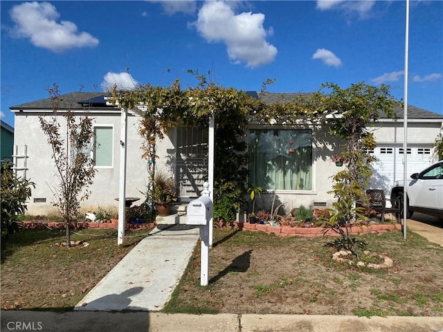 view of front facade with stucco siding and crawl space