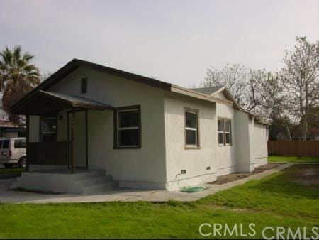 exterior space with crawl space, a yard, and stucco siding