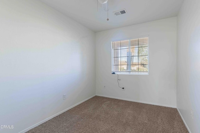 spare room with carpet, visible vents, and baseboards