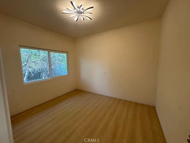 empty room with light wood finished floors and baseboards