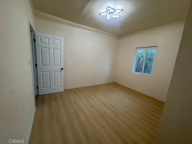 unfurnished room with baseboards and wood finished floors