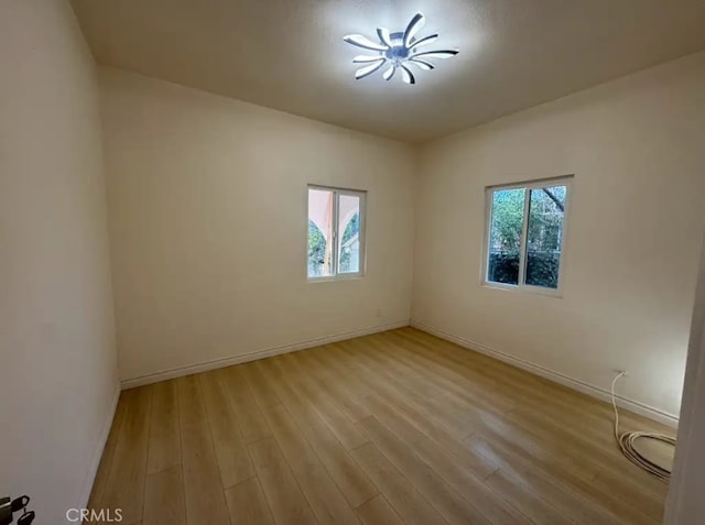 empty room featuring baseboards and wood finished floors