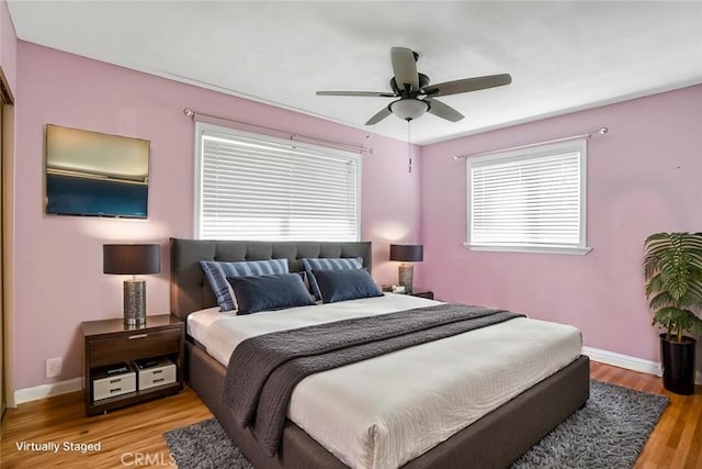 bedroom with baseboards, light wood finished floors, and ceiling fan