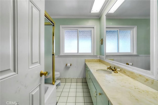 full bath with a wealth of natural light, a wainscoted wall, toilet, and vanity