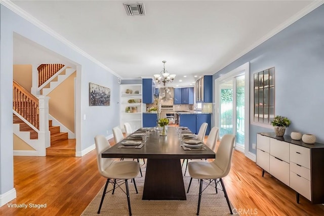 dining area with crown molding, light wood-style flooring, and visible vents