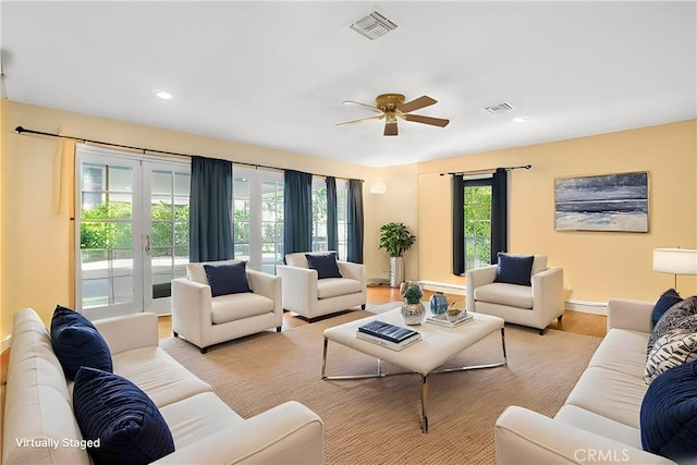 living room with recessed lighting, visible vents, french doors, and light wood finished floors