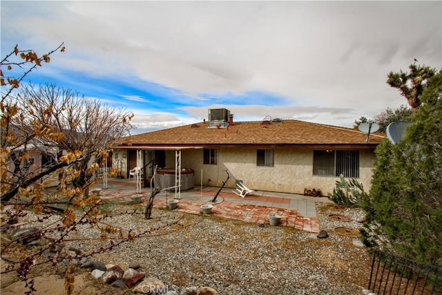 rear view of property with a patio area, central AC, and stucco siding