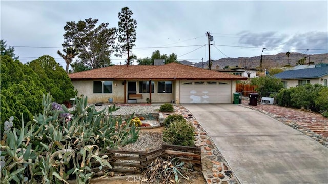 single story home featuring concrete driveway, fence, a garage, and stucco siding