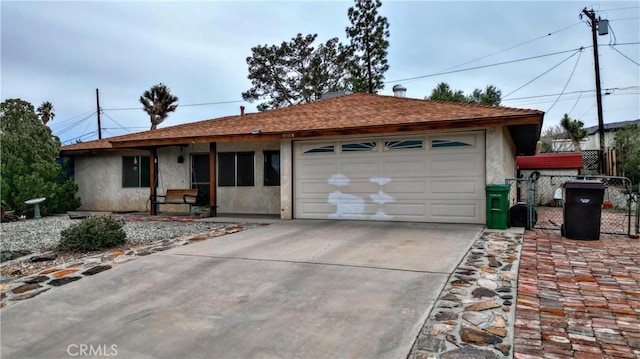 ranch-style home featuring fence, roof with shingles, stucco siding, concrete driveway, and a garage