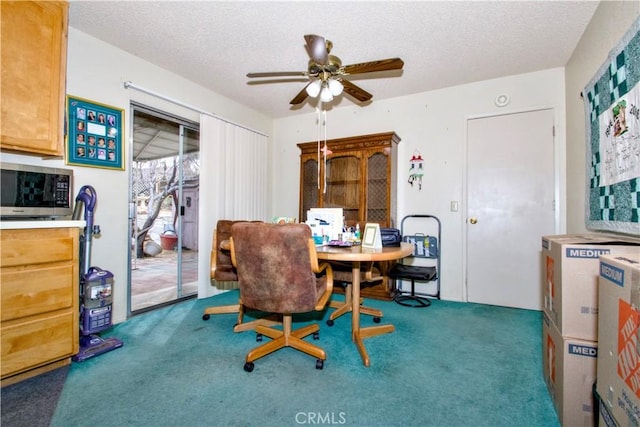 dining room with a ceiling fan, carpet floors, and a textured ceiling