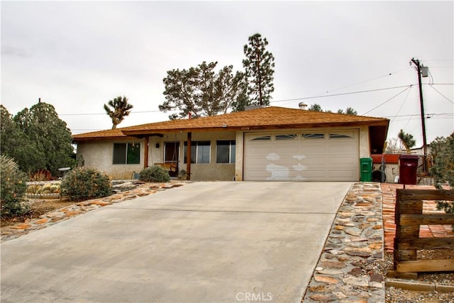 ranch-style home featuring stucco siding, concrete driveway, and a garage