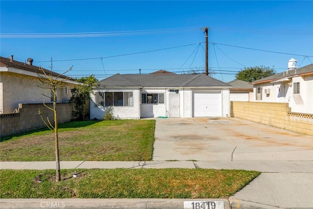 ranch-style house featuring a front yard, concrete driveway, fence, and a garage