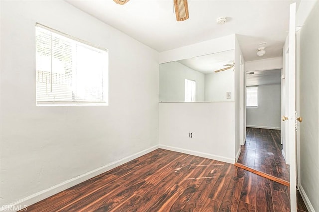 spare room featuring baseboards, ceiling fan, and wood-type flooring