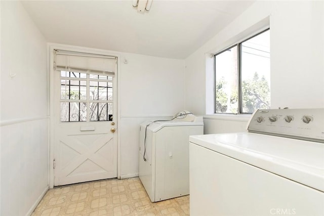 washroom with laundry area, light floors, independent washer and dryer, and wainscoting