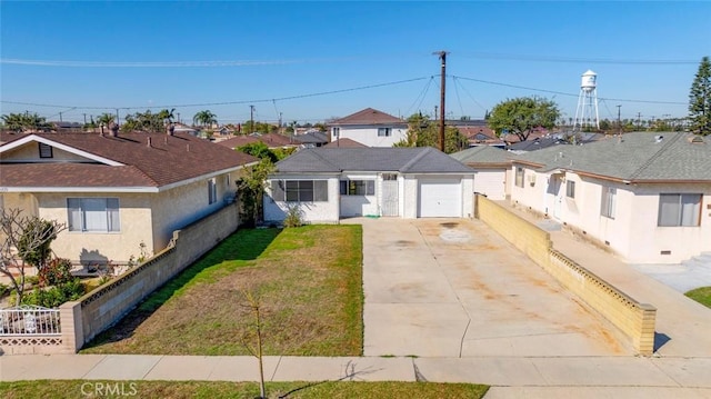 view of front of property featuring a garage, a residential view, driveway, and fence