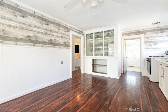 interior space with visible vents, baseboards, dark wood-style floors, and a ceiling fan