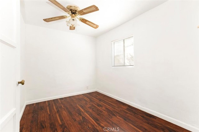 empty room featuring a ceiling fan, baseboards, and dark wood-style flooring