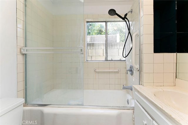 full bath featuring vanity, toilet, and bath / shower combo with glass door