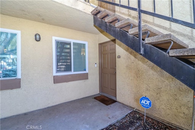 doorway to property featuring stucco siding