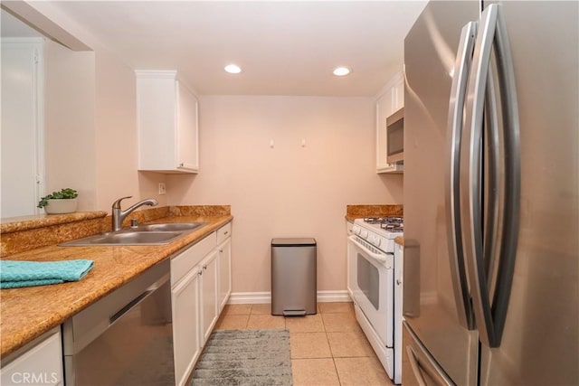 kitchen with a sink, recessed lighting, appliances with stainless steel finishes, white cabinets, and light tile patterned floors