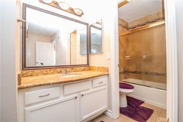 bathroom featuring tile patterned floors, combined bath / shower with glass door, toilet, and vanity