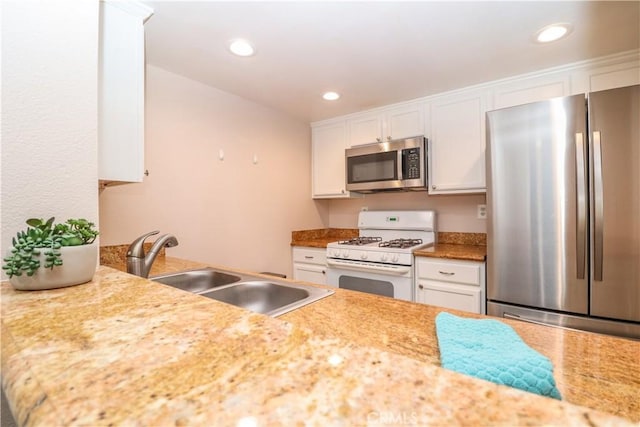 kitchen with a sink, white cabinetry, recessed lighting, appliances with stainless steel finishes, and light countertops