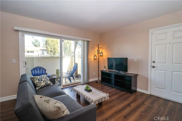 living area with baseboards and wood finished floors