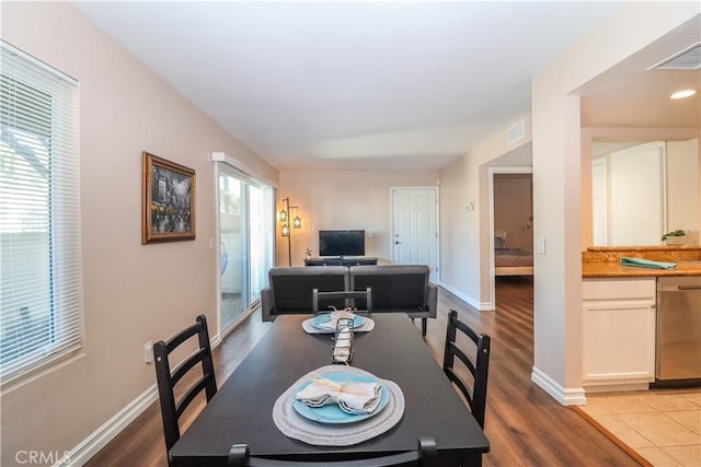 dining space featuring visible vents, baseboards, and wood finished floors