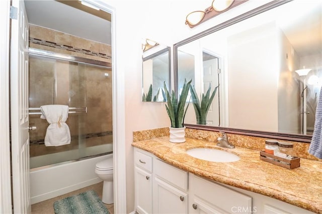 bathroom with tile patterned floors, bath / shower combo with glass door, toilet, and vanity