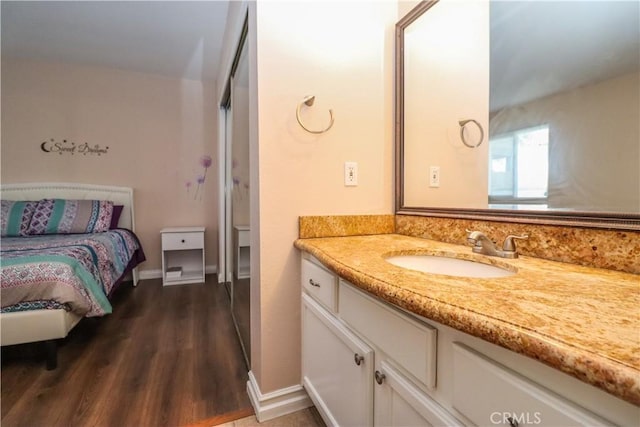 bathroom with vanity, baseboards, and wood finished floors