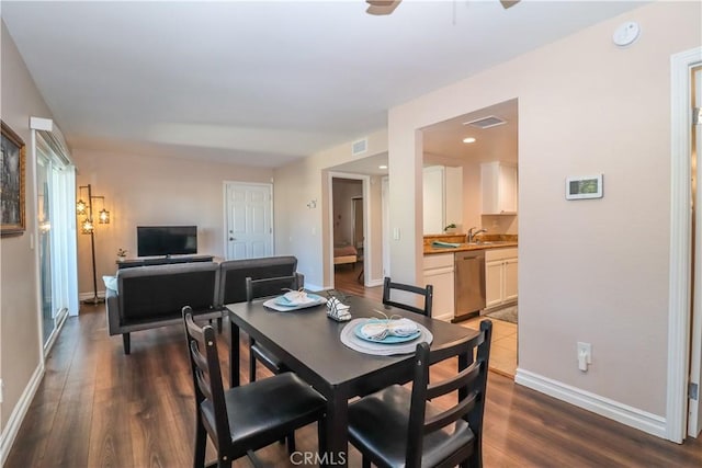 dining area with visible vents, dark wood-style flooring, and baseboards