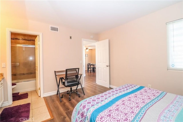 bedroom featuring visible vents, baseboards, and wood finished floors