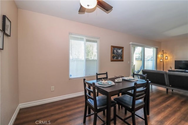 dining area featuring dark wood-type flooring, baseboards, and ceiling fan