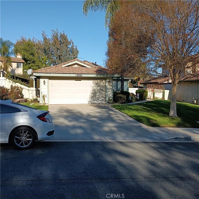 ranch-style home with a garage, driveway, a front yard, and fence