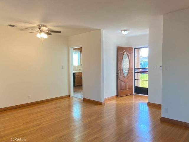 entrance foyer with visible vents, light wood-style flooring, a ceiling fan, and baseboards