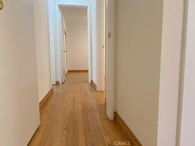 hallway with light wood-style floors and baseboards