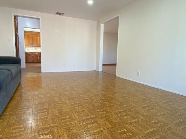 unfurnished living room with baseboards and visible vents