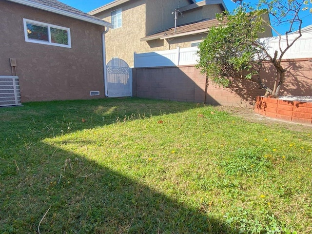 view of yard with central AC unit and fence